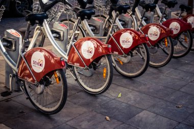 Seville, İspanya, 21 Eylül 2025 Sevilla 'nın tarihi şehir merkezinde, dar, pitoresk caddelerden kiralamak için bisiklet.