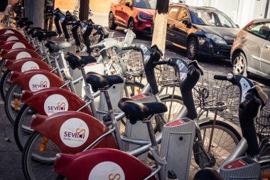 Seville, İspanya, 21 Eylül 2025 Sevilla 'nın tarihi şehir merkezinde, dar, pitoresk caddelerden kiralamak için bisiklet.