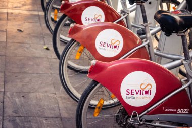 Seville, İspanya, 21 Eylül 2025 Sevilla 'nın tarihi şehir merkezinde, dar, pitoresk caddelerden kiralamak için bisiklet.