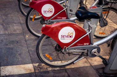 Seville, İspanya, 21 Eylül 2025 Sevilla 'nın tarihi şehir merkezinde, dar, pitoresk caddelerden kiralamak için bisiklet.