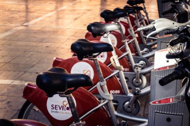 Seville, İspanya, 21 Eylül 2025 Sevilla 'nın tarihi şehir merkezinde, dar, pitoresk caddelerden kiralamak için bisiklet.