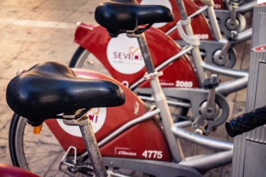 Seville, İspanya, 21 Eylül 2025 Sevilla 'nın tarihi şehir merkezinde, dar, pitoresk caddelerden kiralamak için bisiklet.