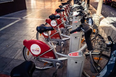 Seville, İspanya, 21 Eylül 2025 Sevilla 'nın tarihi şehir merkezinde, dar, pitoresk caddelerden kiralamak için bisiklet.