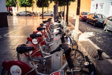 Seville, İspanya, 21 Eylül 2025 Sevilla 'nın tarihi şehir merkezinde, dar, pitoresk caddelerden kiralamak için bisiklet.