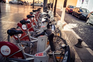 Seville, İspanya, 21 Eylül 2025 Sevilla 'nın tarihi şehir merkezinde, dar, pitoresk caddelerden kiralamak için bisiklet.