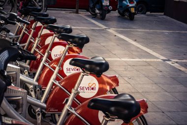 Seville, İspanya, 21 Eylül 2025 Sevilla 'nın tarihi şehir merkezinde, dar, pitoresk caddelerden kiralamak için bisiklet.