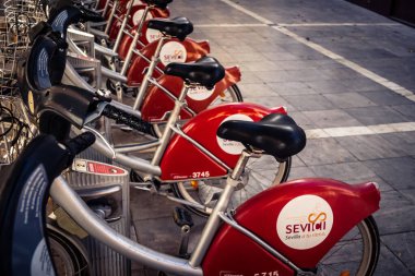 Seville, İspanya, 21 Eylül 2025 Sevilla 'nın tarihi şehir merkezinde, dar, pitoresk caddelerden kiralamak için bisiklet.
