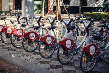 Seville, İspanya, 21 Eylül 2025 Sevilla 'nın tarihi şehir merkezinde, dar, pitoresk caddelerden kiralamak için bisiklet.
