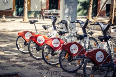 Seville, İspanya, 21 Eylül 2025 Sevilla 'nın tarihi şehir merkezinde, dar, pitoresk caddelerden kiralamak için bisiklet.