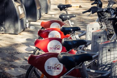 Seville, İspanya, 21 Eylül 2025 Sevilla 'nın tarihi şehir merkezinde, dar, pitoresk caddelerden kiralamak için bisiklet.