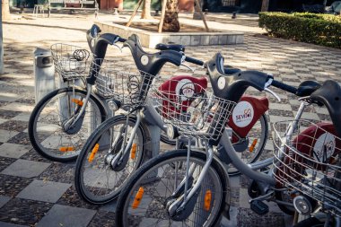 Seville, İspanya, 21 Eylül 2025 Sevilla 'nın tarihi şehir merkezinde, dar, pitoresk caddelerden kiralamak için bisiklet.