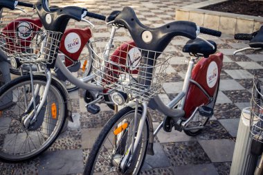 Seville, İspanya, 21 Eylül 2025 Sevilla 'nın tarihi şehir merkezinde, dar, pitoresk caddelerden kiralamak için bisiklet.
