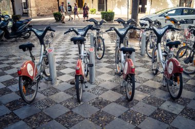 Seville, İspanya, 21 Eylül 2025 Sevilla 'nın tarihi şehir merkezinde, dar, pitoresk caddelerden kiralamak için bisiklet.