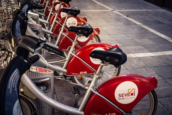 Seville, İspanya, 21 Eylül 2025 Sevilla 'nın tarihi şehir merkezinde, dar, pitoresk caddelerden kiralamak için bisiklet.