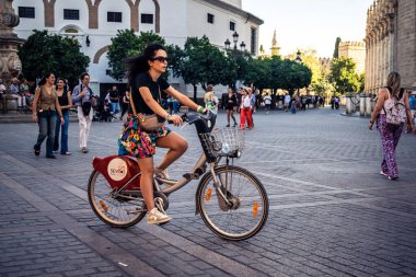 Seville, İspanya, 28 Eylül 2025 Bisikletli Turistler Sevilla şehir merkezinin tarihi bölgesini ziyaret edip dar, pitoresk caddelerde geziniyorlar..