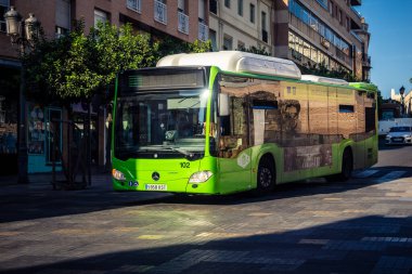 Cordoba, İspanya, 2 Ekim 2025. Otobüs Cordoba 'nın tarihi şehir merkezinde dar ve pitoresk sokaklardan geçiyor. Otobüsler Cordoba 'daki en popüler ulaşım araçlarından biridir..