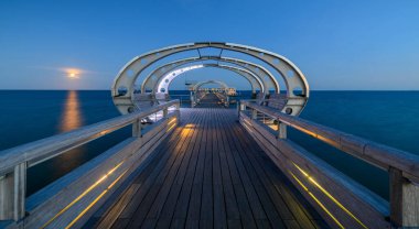 Illuminated pier on the Baltic Sea resort of Kellenhusen after sunset. View of Baltic sea resort Kellenhusen with its famous pier, Schleswig-Holstein, Germany. 