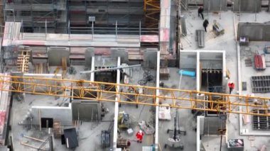  Construction workers in a building site. Construction worker fasten construction waste to the chains. Aerial top view of working tower crane. Building construction, construction industry. 