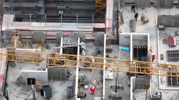 建築現場の建設労働者 建設労働者はチェーンに建設廃棄物を固定します 作業塔クレーンの空中トップビュー 建築業 建設業 — ストック動画