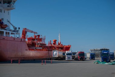 Petrollü gemi tankeri limandaki yakıt kamyonlarına boşaltıldı. Depodaki yakıt kamyonu tankerden yakıt çıkarıyor. Tankerden kamyona boşaltılıyor. 