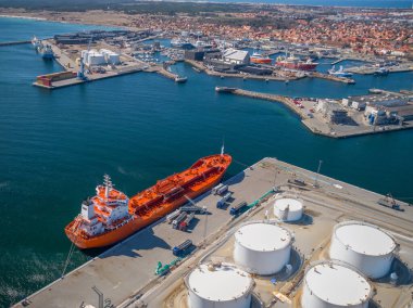 Petrollü gemi tankeri limandaki yakıt kamyonlarına boşaltıldı. Depodaki yakıt kamyonu tankerden yakıt çıkarıyor. Tankerden kamyona boşaltılıyor. 