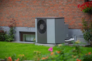 Air heat pump installed on the exterior facade of the old house. Sustainable heating solutions for old construction. Air source heat pump beside residential country cottage. clipart