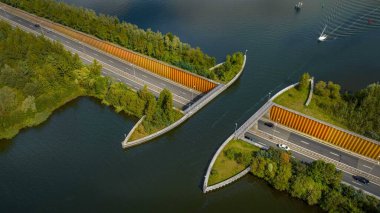 Aquaduct Veluwemeer su köprüsünün görüntüsü araç ve su aracılığı ile geçen trafiğin birbirlerinin üzerinden ya da altından geçmesine izin veriyor. Su kemerini geçmek için bir yelkenli yaklaşıyor. Veluwemeer, otoyolun üstündeki gölde..