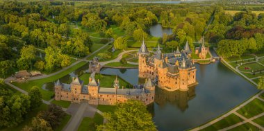 De Haar Kalesi 'nin tipik kuleleri ve peri masalı gibi parlak günlerde parlayan ve bahçeleri güzelleştiren görünüşü. Yeni Gotik Kasteel de haar.