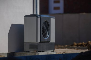İnşaat sırasında çok aileli konutun dış cephesine hava ısı pompası yerleştirildi. Yeni bina için sürdürülebilir ısıtma çözümleri. Çoklu aile konutlarının yanında kaynak ısı pompası. 