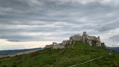 Slovakya 'daki Spissky Hrad Şatosu' nun Timelapse 'ı. Bulutlar ve tur grubu kaleye doğru yükseliyor. Slovakya 'nın doğusundaki Spi Kalesi harabeleri.