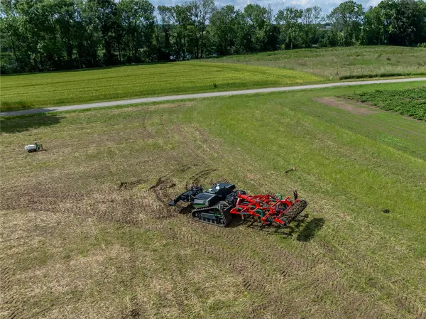 stock image Autonomous agricultural robot equipped with soil-friendly crawler tracks and a attachment for ploughing of fields. Self-driving robot with autopilot using a GPS navigation system for smart farming.