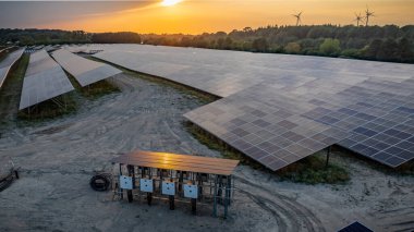 Şu anda yapım aşamasında olan endüstriyel güneş enerjisi santrali güneş modülleri ve güneş enerjisi şebekesine bağlanmak için elektrik kablolarına sahip beyaz kombinasyon kutuları sergiliyor..