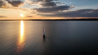 Geri çekiliyoruz, yelkenliden beyaz yelkenliyle uzaklaşıyoruz, batan güneşin ışınlarıyla yıkandık, gün batımında Flensburg Fjord 'un sakin sularını ortaya çıkarıyoruz. Macera ve rahatlama kavramı.