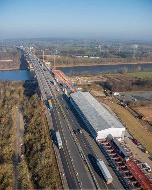Rade 'in Kiel Kanalı üzerinde otoyol köprüsü inşaatı. Rade High Köprüsü, Nord-Ostsee-Kanal üzerinde yapım aşamasında. Birden fazla şeritte trafik var. Geçici yapılar, vinçler, bir inşaat alanı..