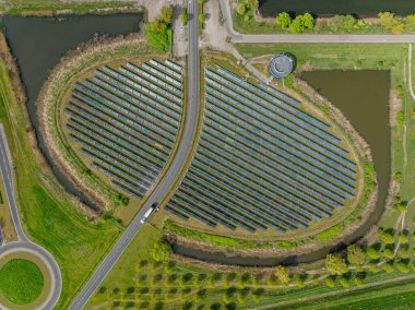 Modern bir güneş enerjisi santralinin havadan görünüşü bir otobüs şeridiyle kesişiyor. Hollanda, Almere 'de otobüs yolu bulunan güneş paneli adası (Zoneiland).