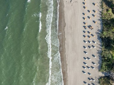 Baltık Denizi sahilinin yukarıdan aşağı manzarası. Sahil sandalyeleri ve kumlu sahile vuran dalgalar. Sahil beldesi Timmendorfer Strand.