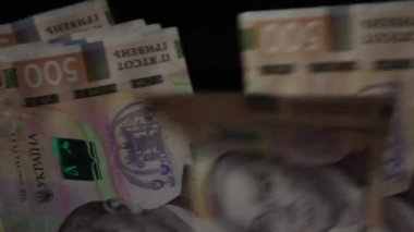 Eller siyah arka planda bir paket Ukrayna hrivniası sayıyor. Ev bütçesi kavramı. Enflasyon, para kaybı ve yükselen fiyatlar. Yüksek kalite 4k görüntü