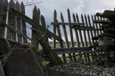 Broken fence. A rickety wooden fence. A breach in the fence. Old wooden fence. High quality photo