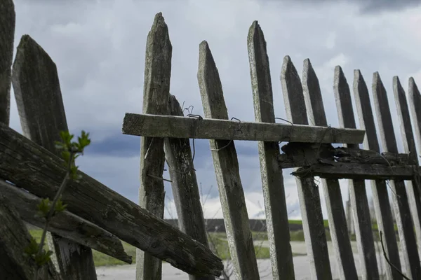 Broken fence. A rickety wooden fence. A breach in the fence. Old wooden fence. High quality photo