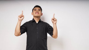 Gülümseyen mutlu Asyalı adam iki elini de beyaz arka planda gösteriyor. Stüdyo çekimi