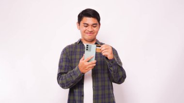 Beyaz arka plan üzerinden cep telefonu ödemelerini yapan Asyalı bir adam.