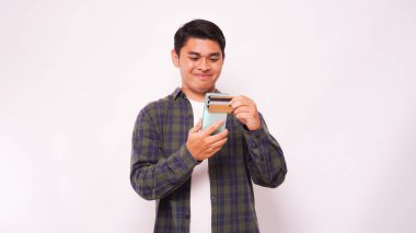 Beyaz arka plan üzerinden cep telefonu ödemelerini yapan Asyalı bir adam.