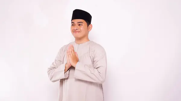 Ramazan 'da selamlaşmak için gülümseyen Asyalı Müslüman adam ve beyaz arka planda bayram kutlamaları