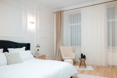 Interior master bedroom details with white bedding and green bed