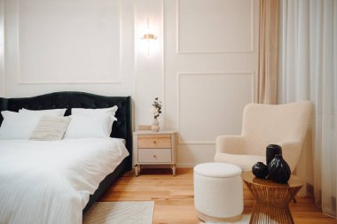 Luxury and stylish bedroom interior with king size bed, white bedding and modern light fixtures and beautiful nightstands