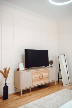 master bedroom with modern design, furniture, wooden coffee tables, plaid, pillows, tropical plants and elegant personal accessories in stylish home decor. Neutral bedroom design