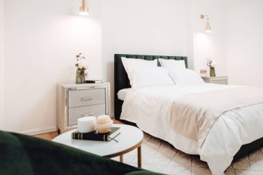 Stylish and cozy bedroom with bedding and modern furniture