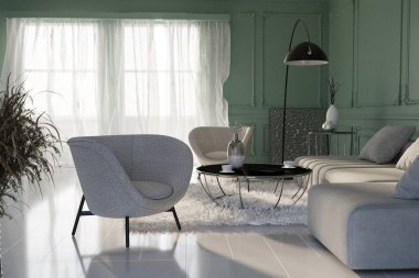 Modern dairenin şık, lüks bir iç mekanı. Basit yumuşak bej mobilyalar, siyah lamba, kahve masaları ve güzel pastel yeşil duvarları var. Gündüz vakti oturma odasında güneş ışınları...
