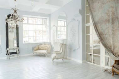Lüks zengin oturma odası iç tasarım zarif klasik mobilyalar ve duvar süslemeleri ile. Büyük pencereli büyük ışık beyaz Oda