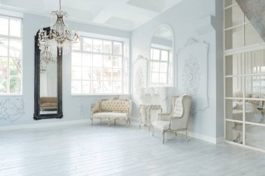 Lüks zengin oturma odası iç tasarım zarif klasik mobilyalar ve duvar süslemeleri ile. Büyük pencereli büyük ışık beyaz Oda